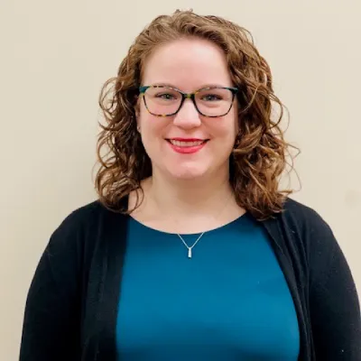 A woman with glasses and a blue shirt