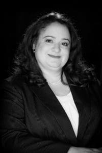 A black and white photo of a woman in a suit.