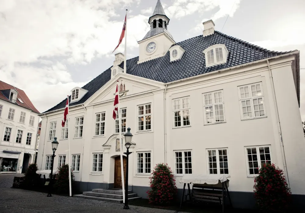 A white building with a clock tower on the top of it.