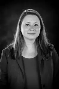 A black and white photo of a woman in a suit.