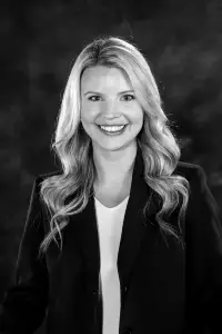 A black and white photo of a woman smiling.