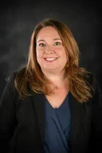 A woman with long hair and wearing a black jacket.