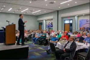 A man standing on stage in front of a crowd.