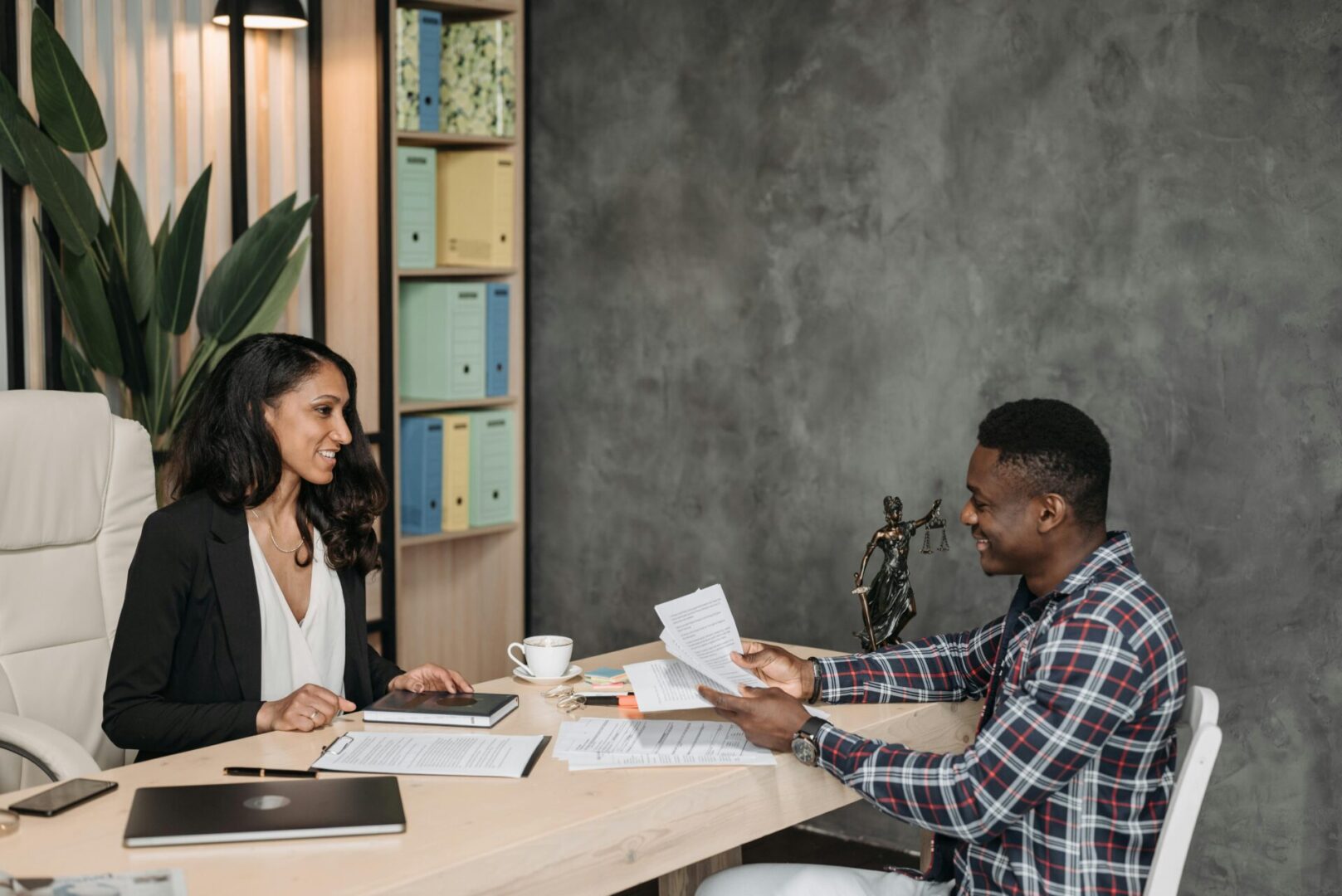 A man and woman sitting at a table with papers.