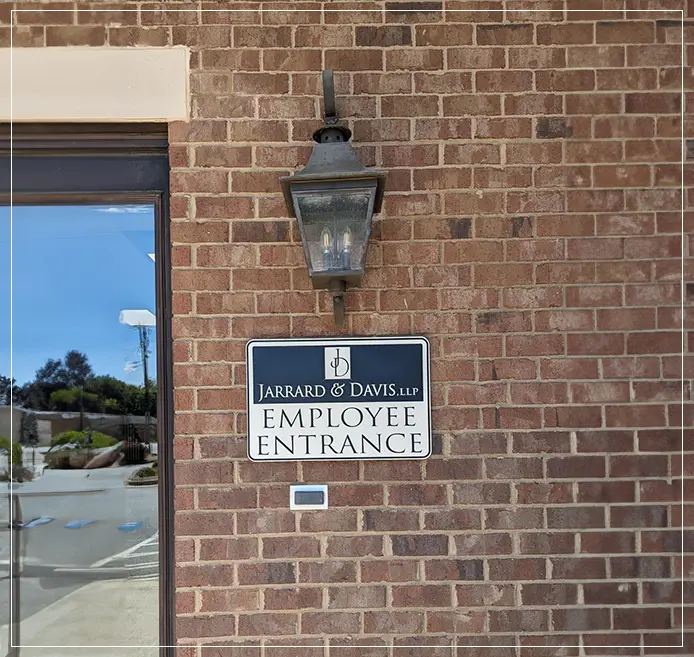 A sign on the side of a building that says " employee entrance."