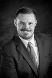 A man in suit and tie smiling for the camera.