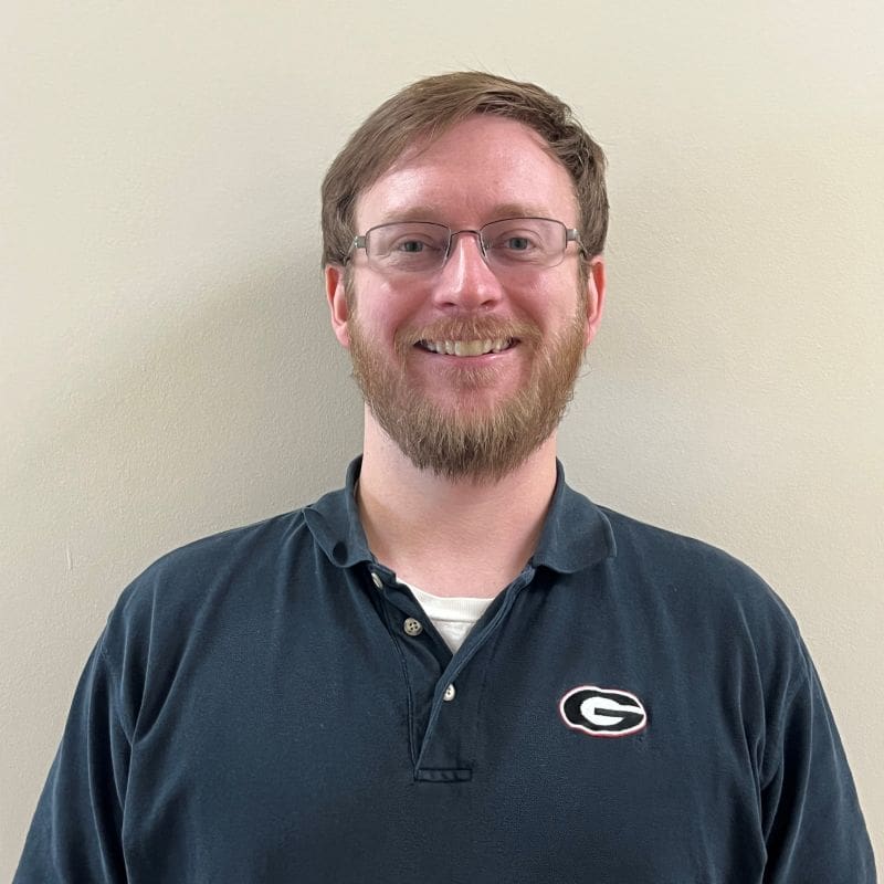 Smiling bearded man wearing glasses and polo